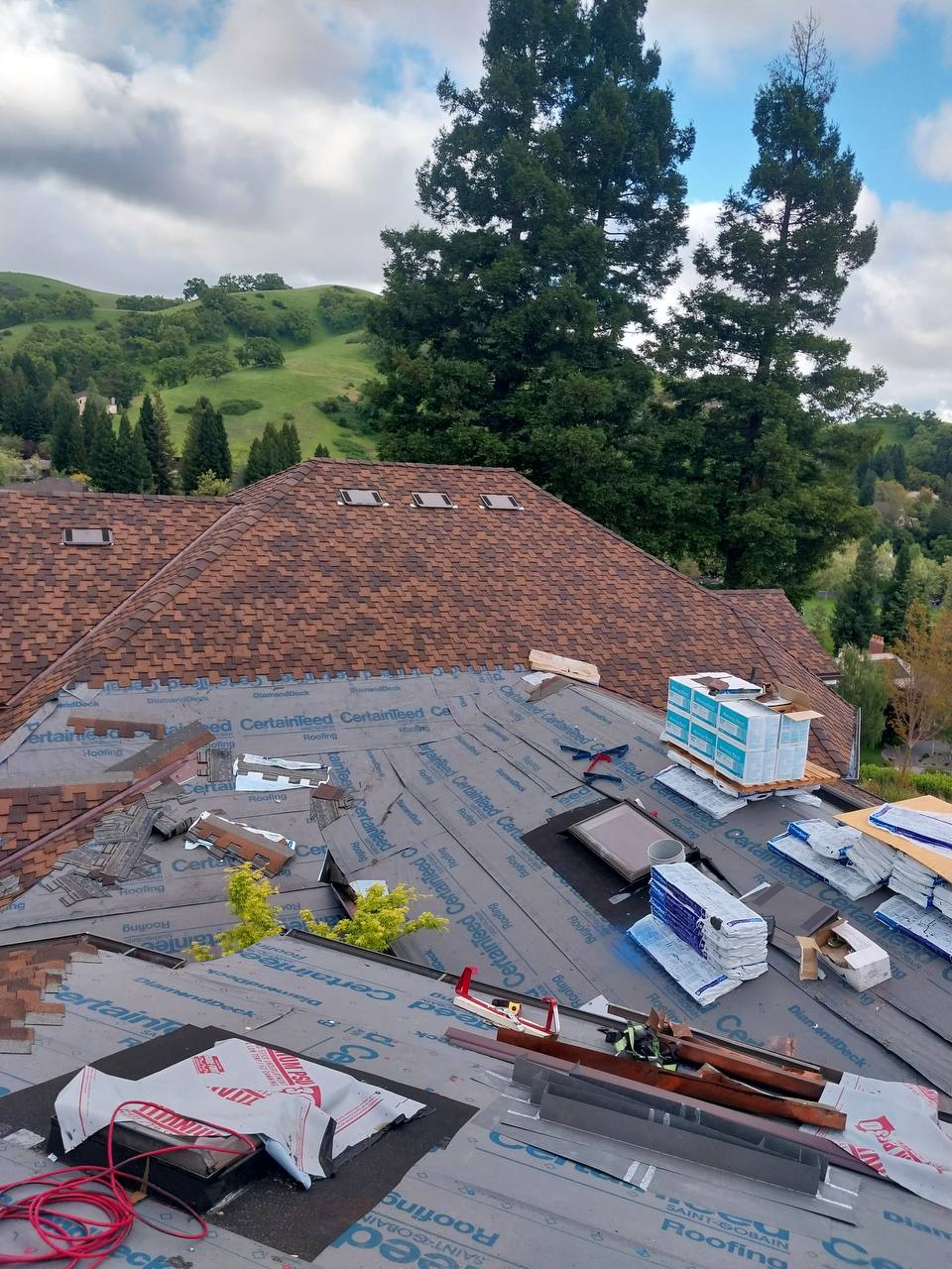 CertainTeed DiamondDeck underlayment and shingle bundles staged during installation